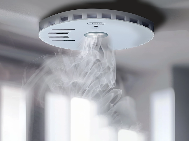 Detector de humo con luz de emergencia, sobre cielorraso, esencial para la seguridad contra incendios y gases tóxicos.