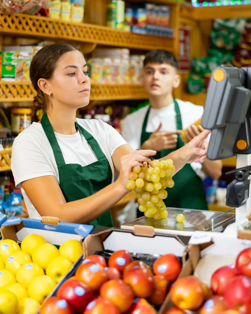 Mujer atendiendo un local de barrio, mostrando una actitud amigable en un ambiente seguro de trabajo.