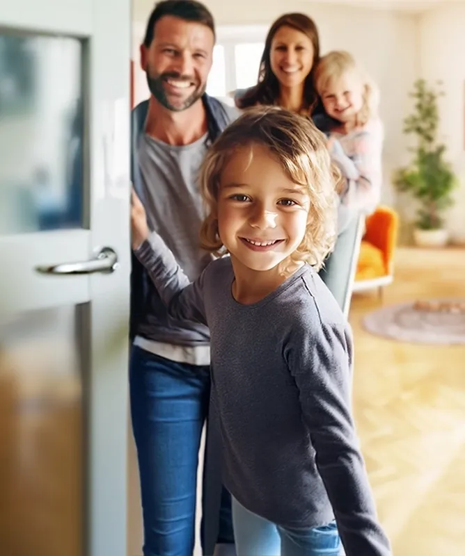 Familia en la entrada de su casa, reflejando felicidad y la tranquilidad que brinda una alarma monitoreada X-28.