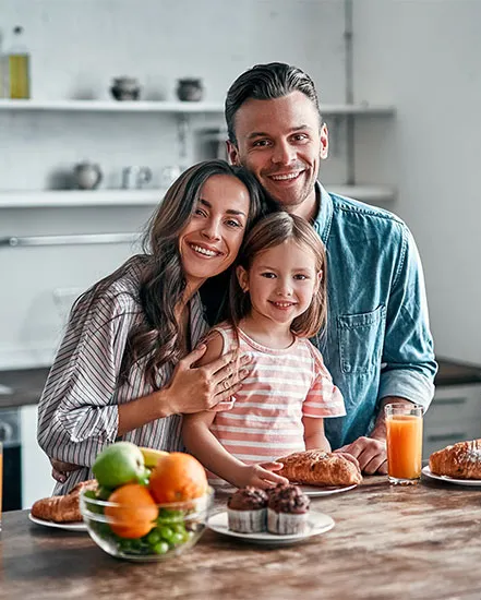 Familia compartiendo un desayuno en la cocina, se percibe un ambiente cálido y seguro.